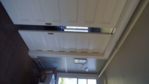 A room with a white door, a ceiling light fixture, and a window. - Hotel Halsingland (Haines)