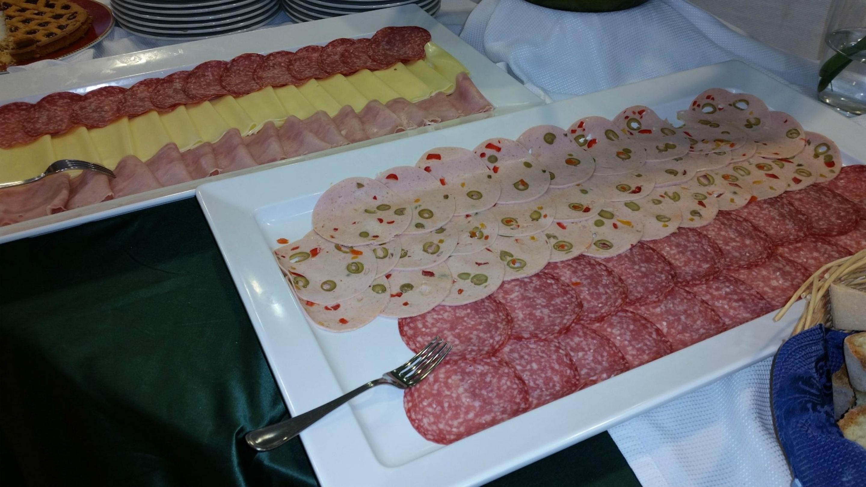 Un bufé con una variedad de embutidos, incluyendo jamón, salami y una selección de quesos.
