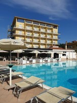 Una piscina al aire libre de temporada, sombrillas