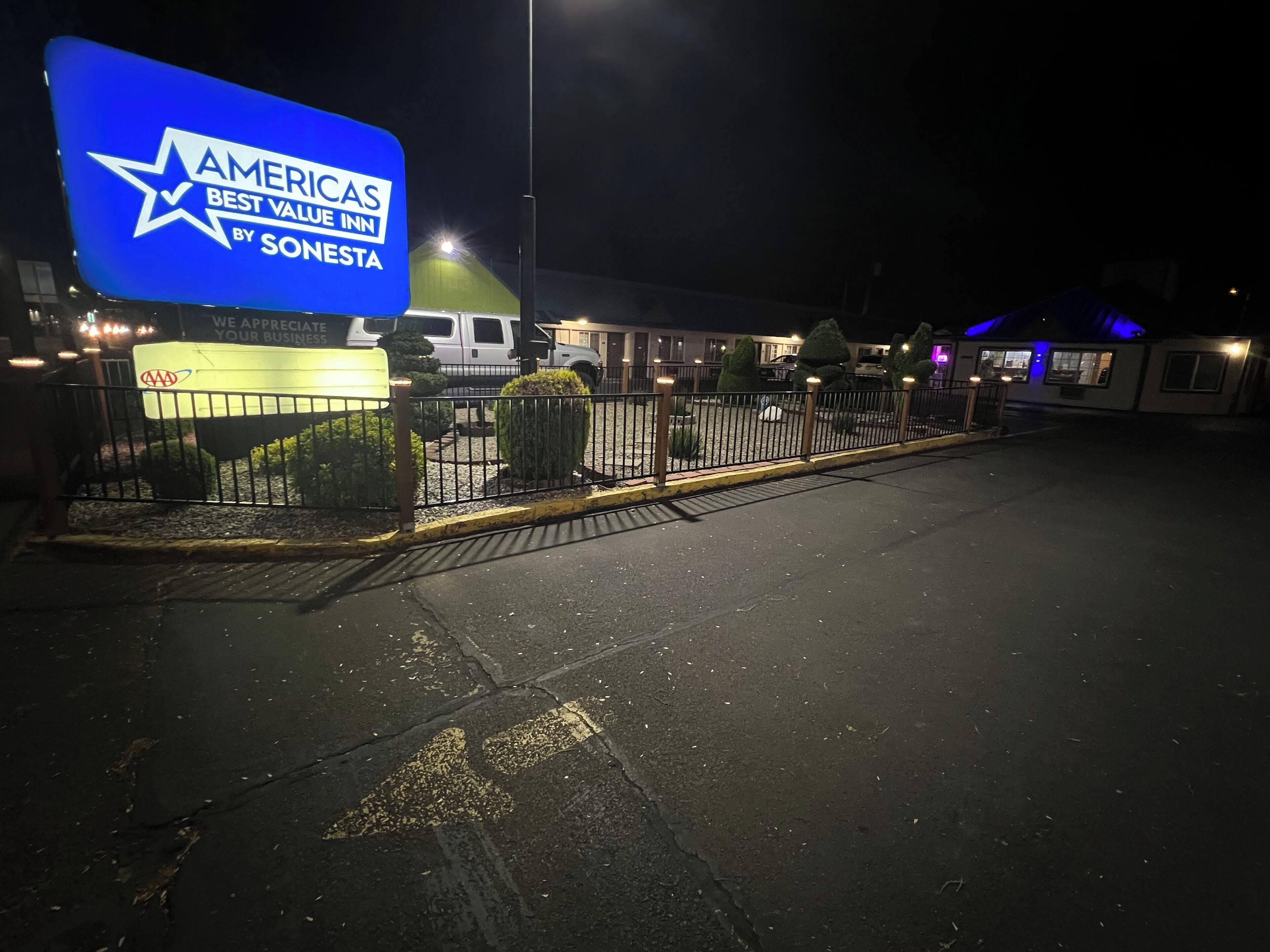 A nighttime view of a hotel with a prominent sign reading "AMERICAS BEST VALUE INN BY SONESTA".