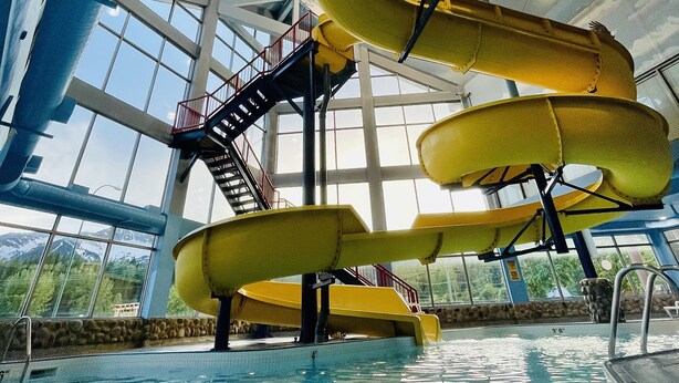 An indoor swimming pool with a large slide structure.