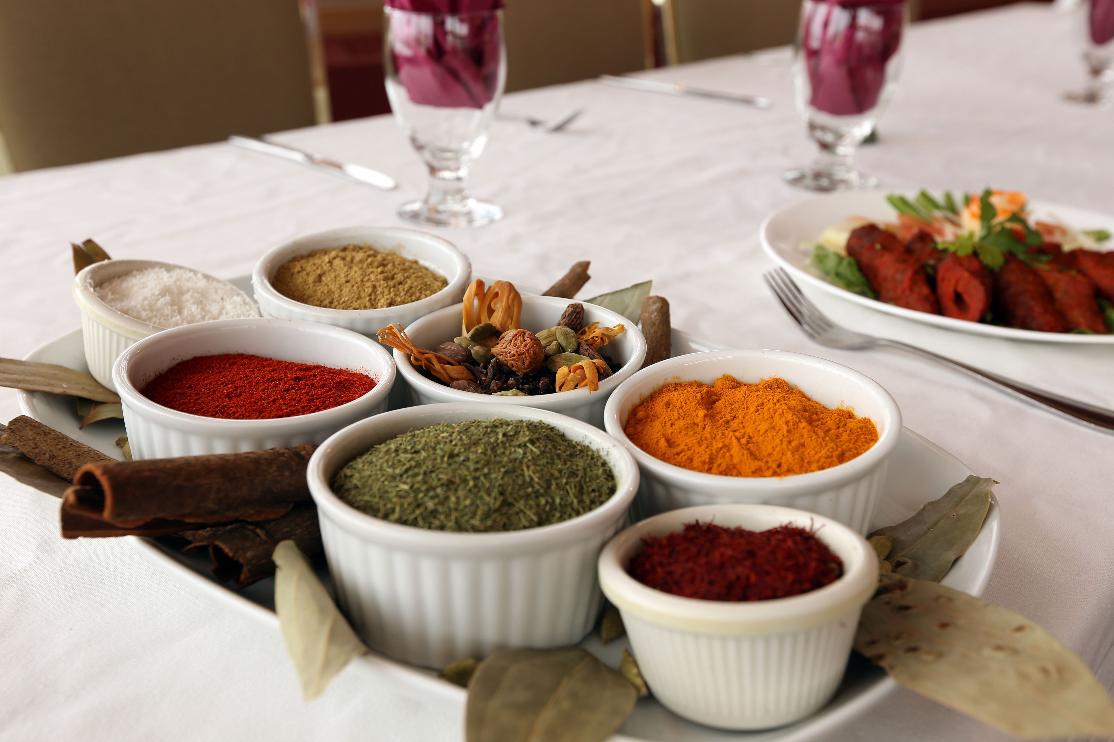 Une table avec différentes épices et une assiette de nourriture.