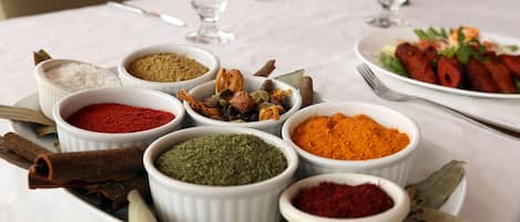 Una mesa con diferentes especias y un plato de comida.