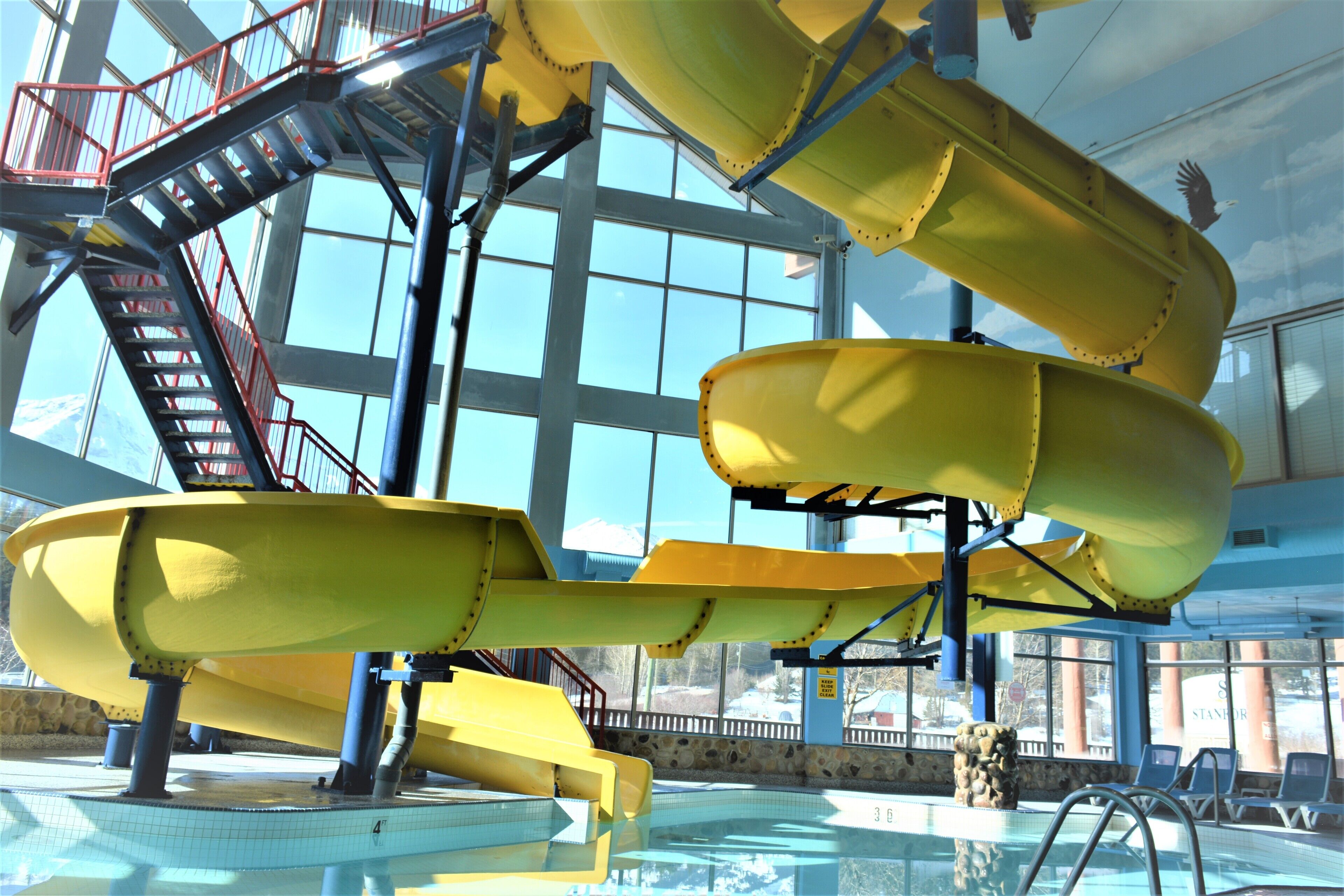 A water slide structure with a staircase and a pool.