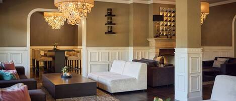 Un amplio salón con muebles modernos, chimenea y lámparas decorativas.