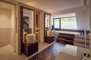 Un baño moderno con dos lavamanos grandes, un espejo amplio y una ventana que ofrece luz natural.