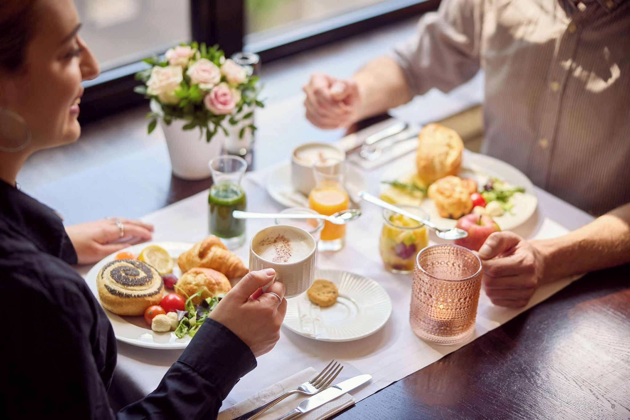 A breakfast setting with a table, plates, and various food items.