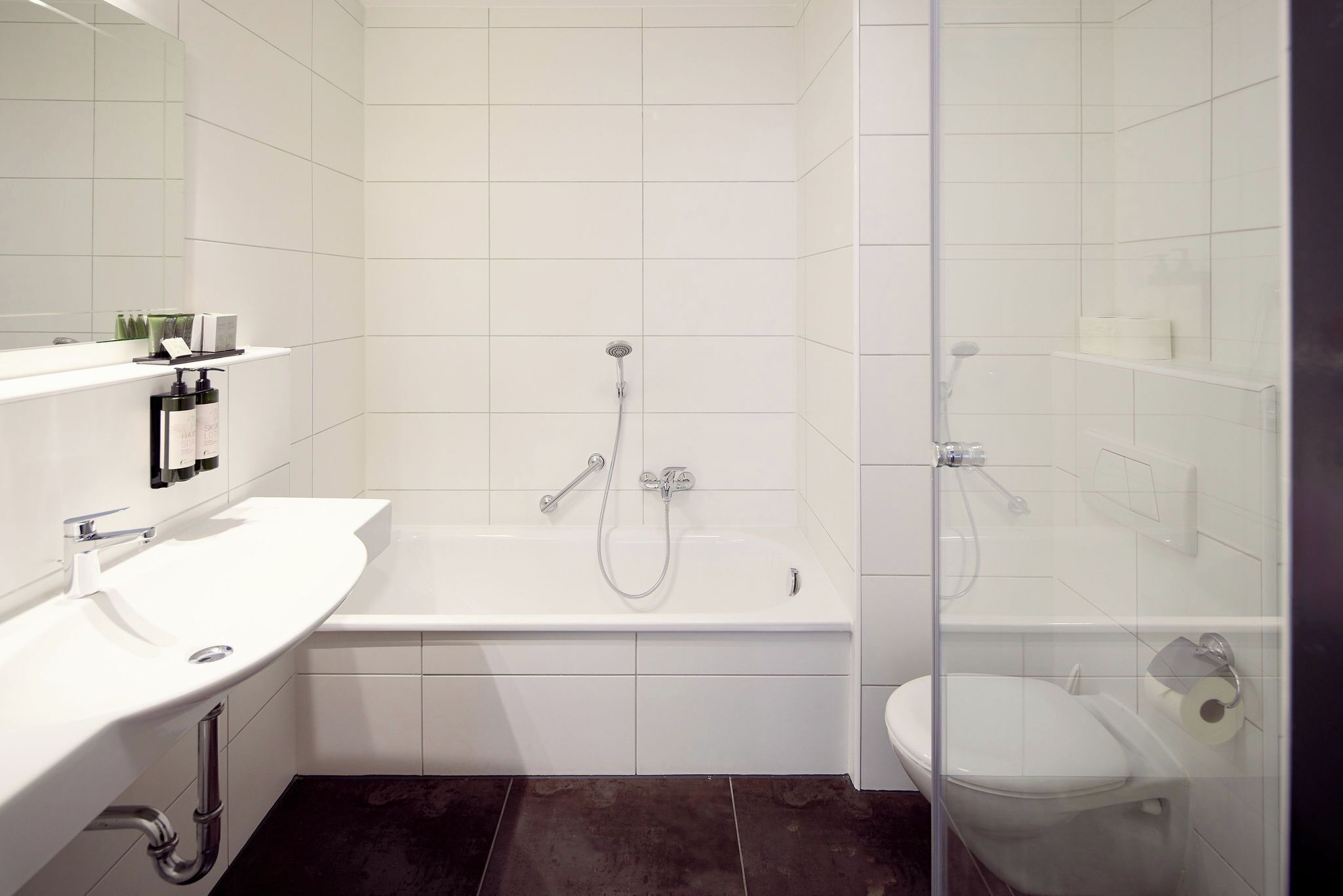 Een moderne badkamer met een wit wastafel, bad en toilet.
