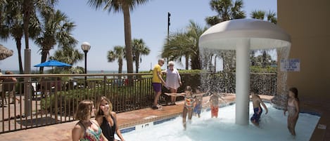 A water play area with palm trees and a clear sky.