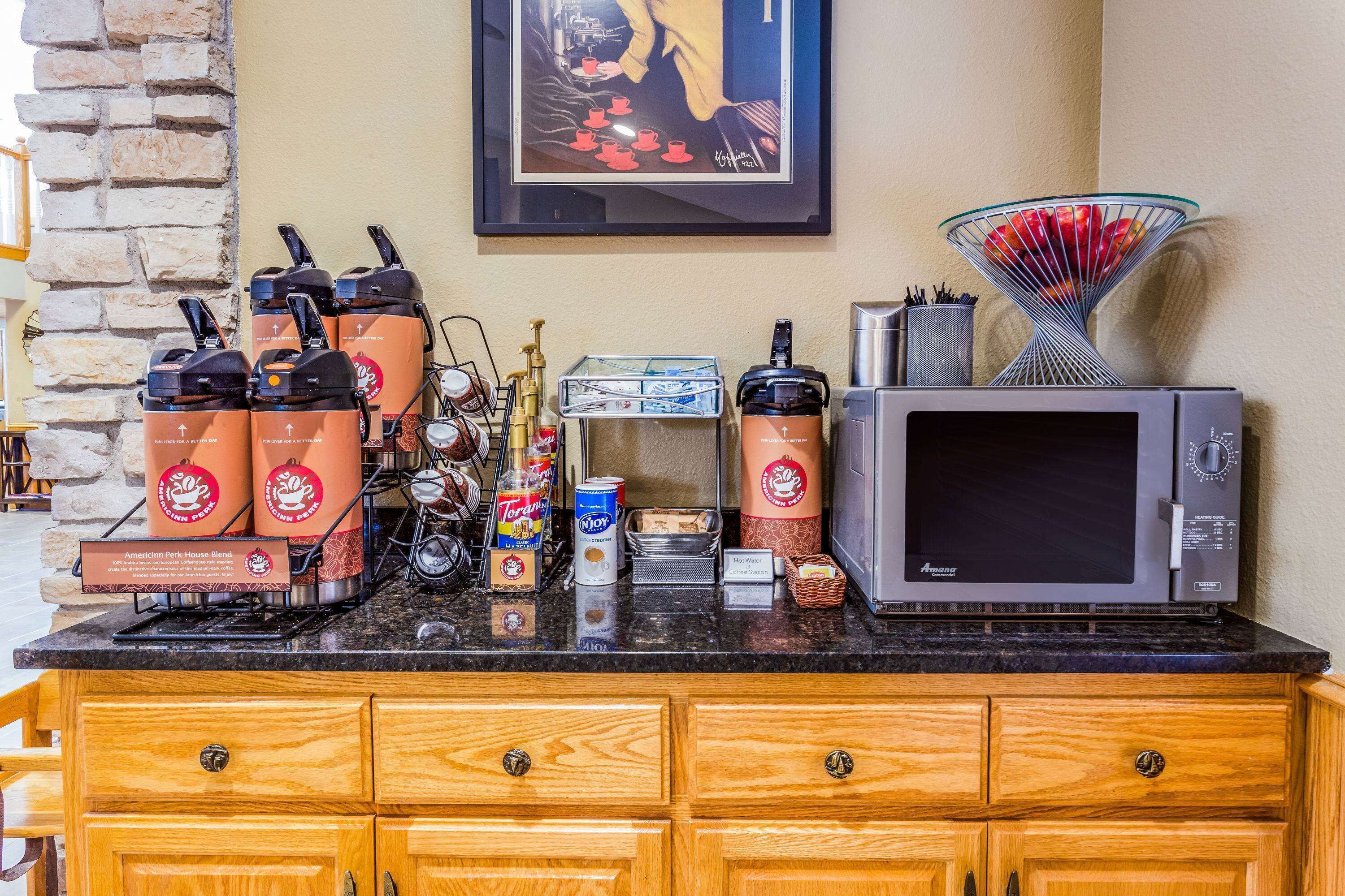A kitchen counter with coffee machines, a microwave, and various kitchen items.