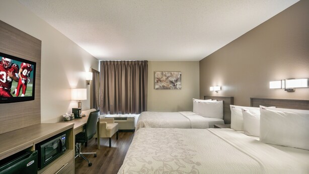 A hotel room with two beds, a desk, a television, and a window with curtains. - Red Roof Inn PLUS+ Boston - Logan (Saugus)