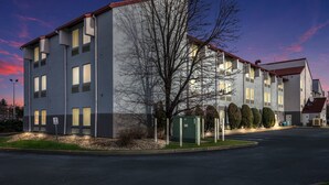 A multi-story building with a flat roof, large windows, and a parking area. - Red Roof Inn PLUS+ Boston - Logan (Saugus)