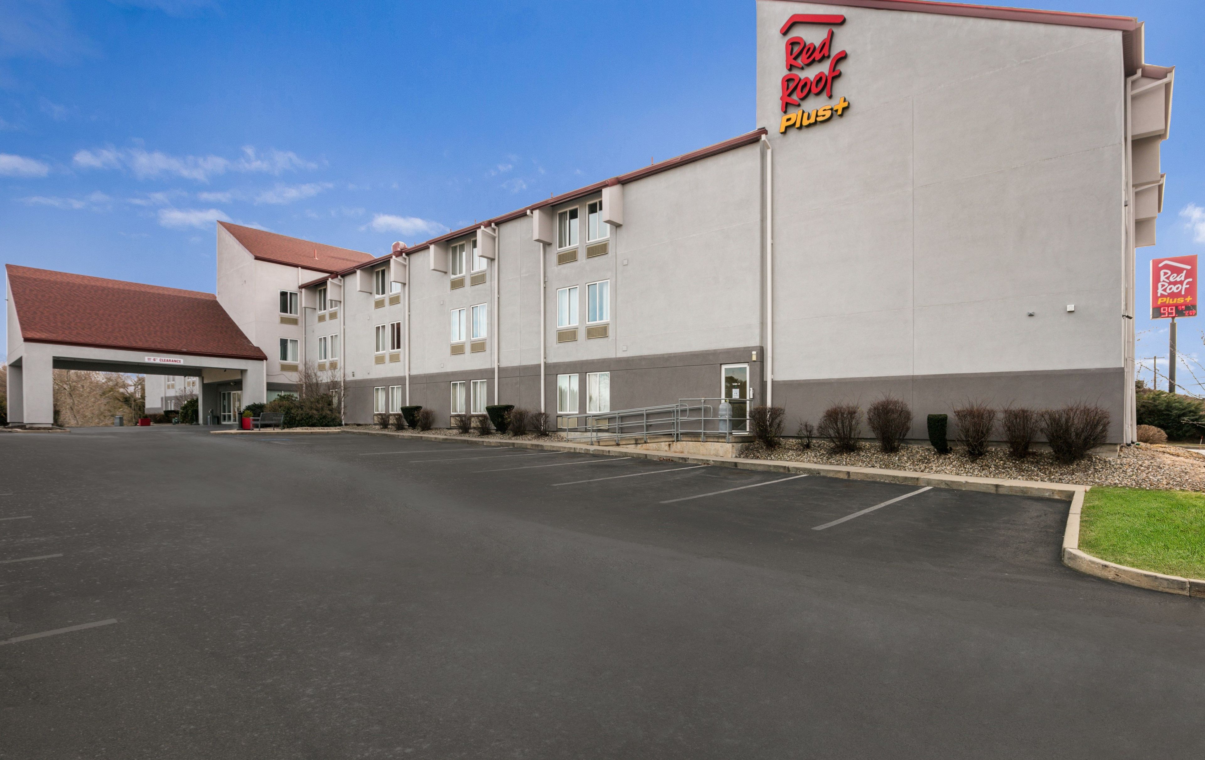 A Red Roof Plus hotel with a parking lot and a covered entrance.
