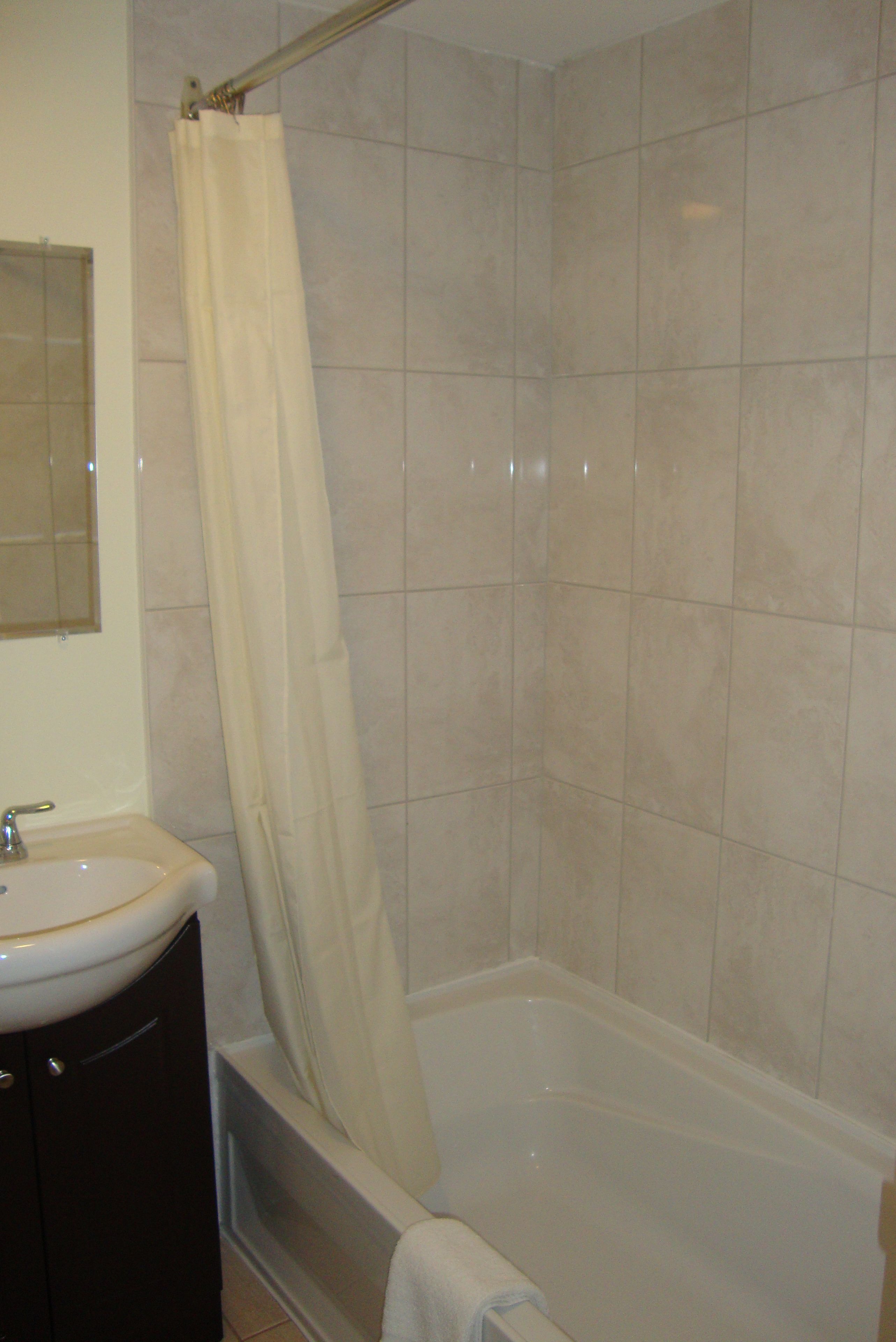Un baño con una bañera, un lavamanos y un espejo.