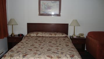 Habitación de hotel con una cama, dos mesitas de noche con lámparas, un teléfono y un cuadro en la pared.