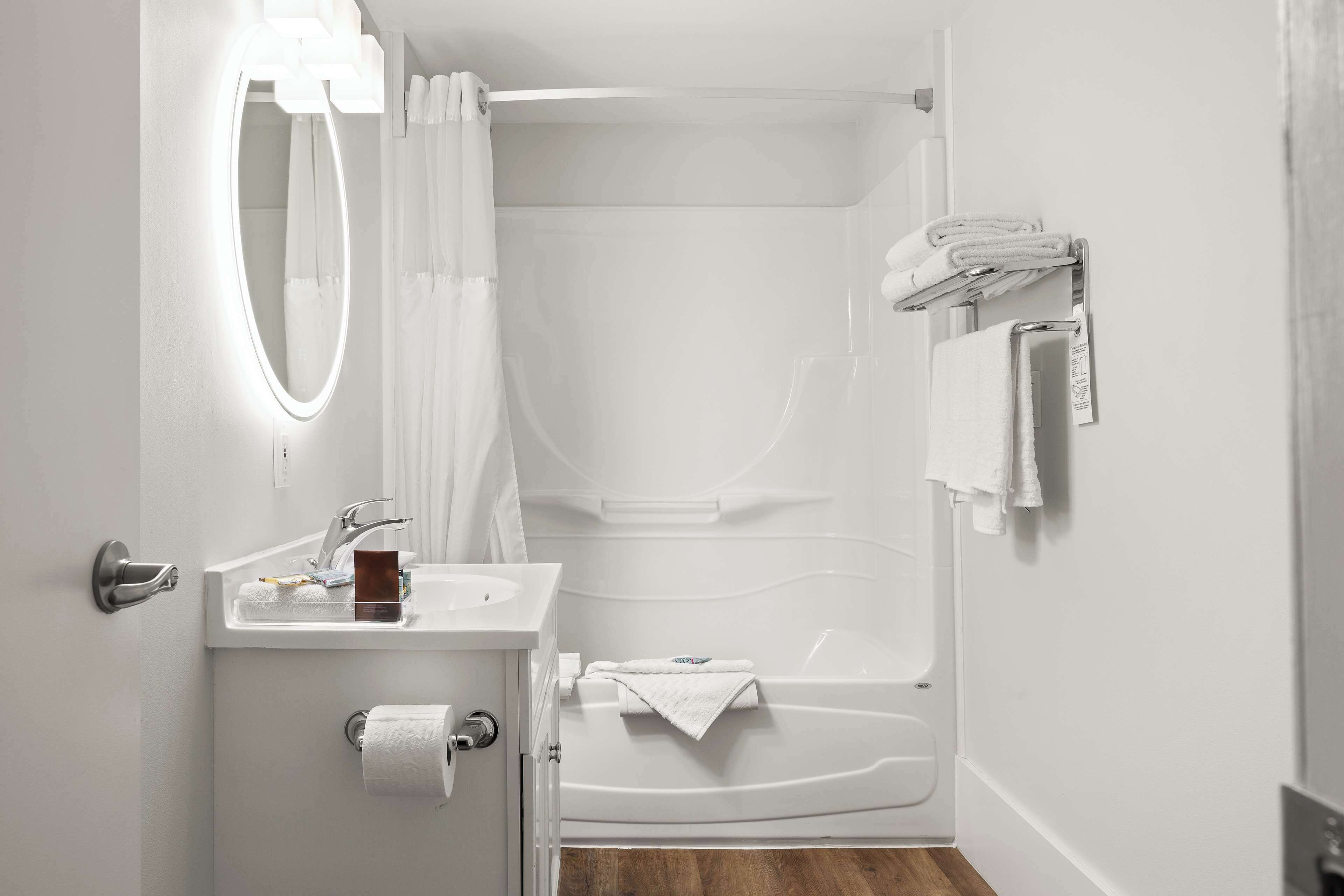 Une salle de bain moderne avec un lavabo blanc, un miroir et une baignoire.