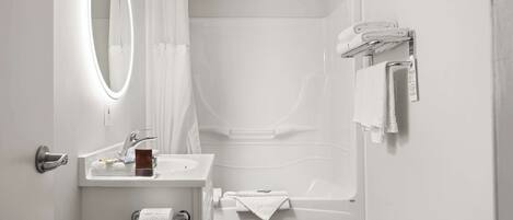 Une salle de bain moderne avec un lavabo blanc, un miroir et une baignoire.