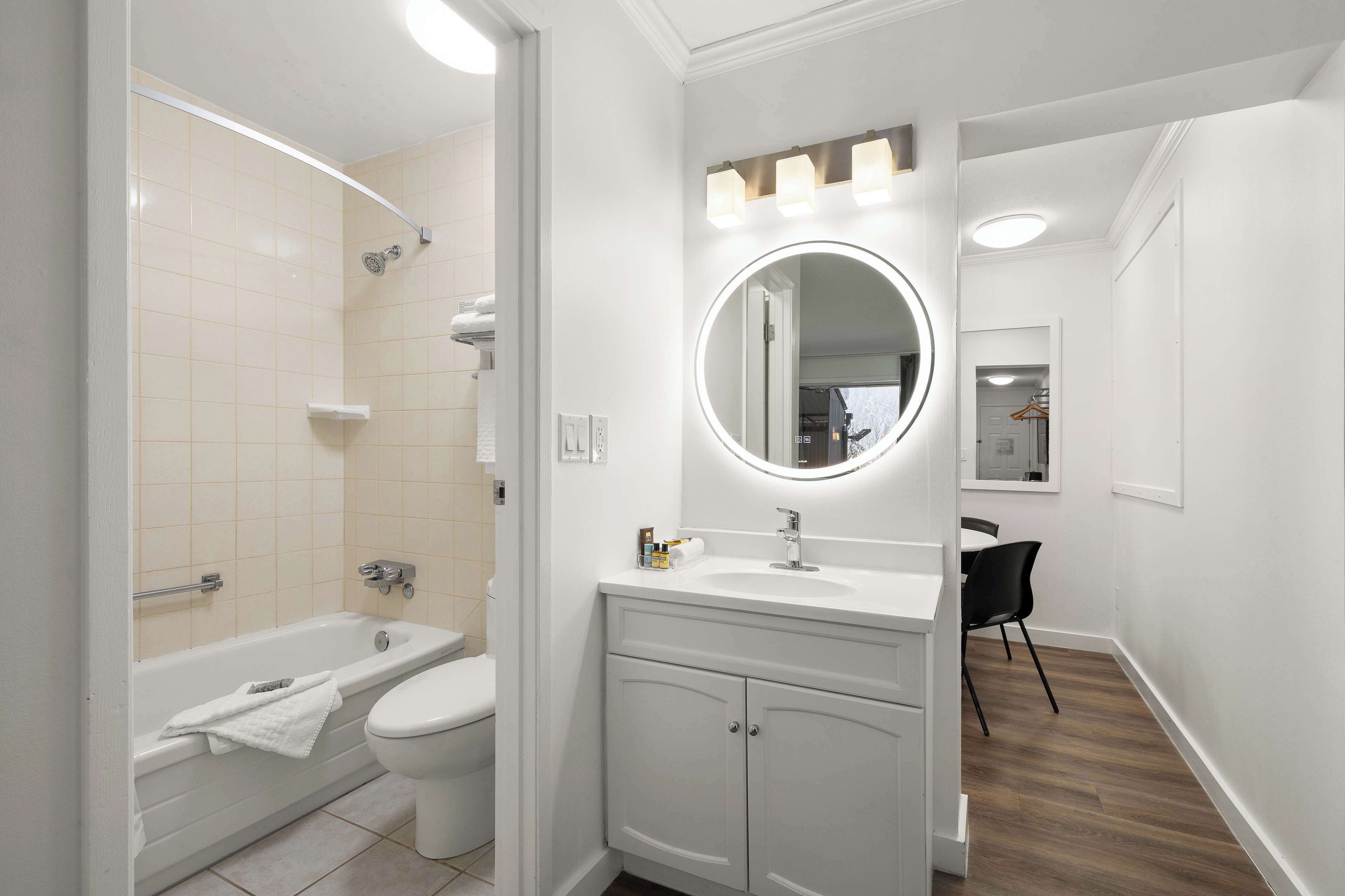 Un bagno moderno con vasca, WC, mobile lavabo con specchio e doccia.