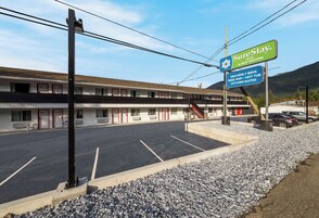 Un motel con un letrero que anuncia SureStay Hotel by Best Western, con servicios como WiFi gratuito, bañera de hidromasaje y suites con cocina.