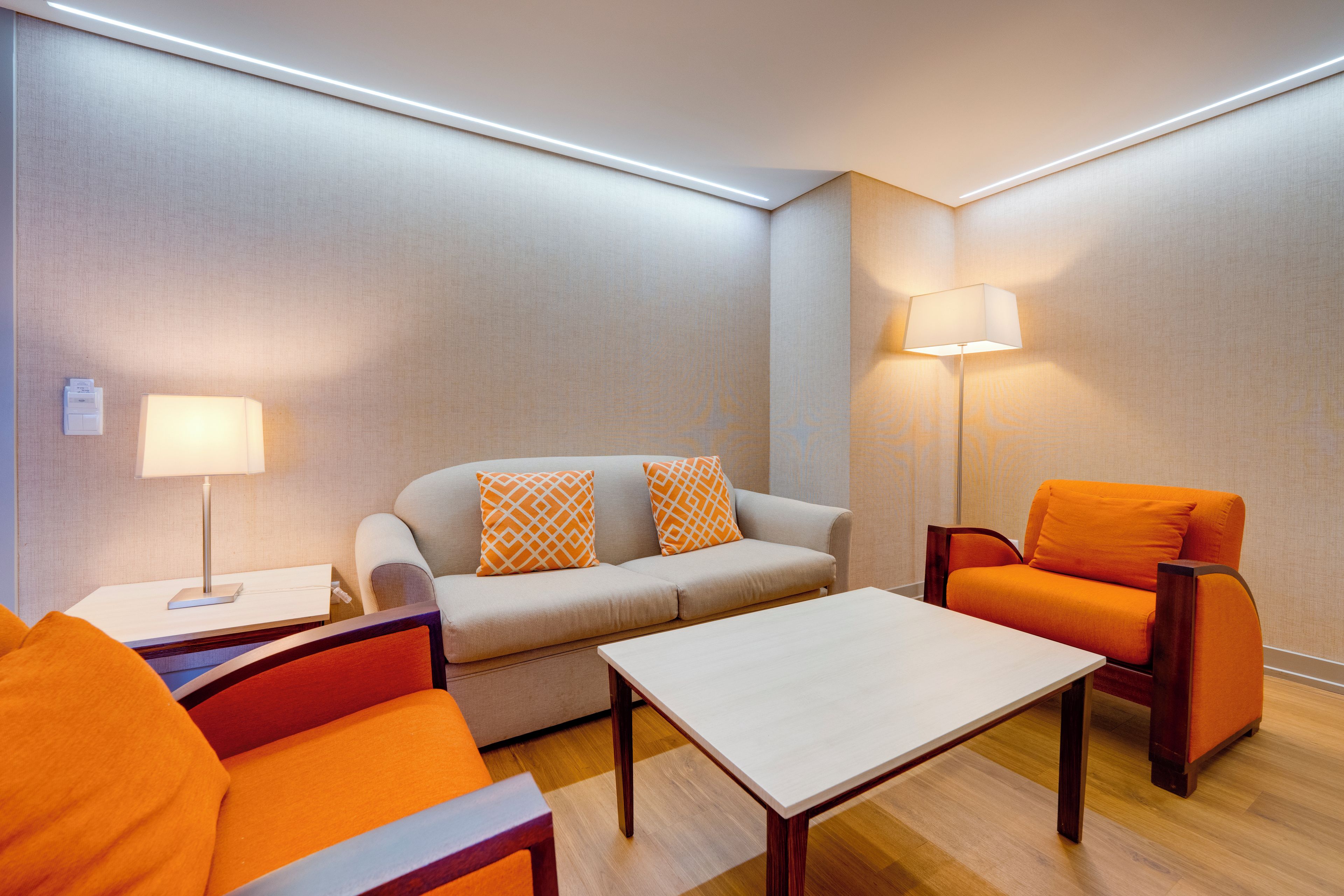 Une chambre d  ’hôtel moderne avec un canapé, un fauteuil et une petite table.