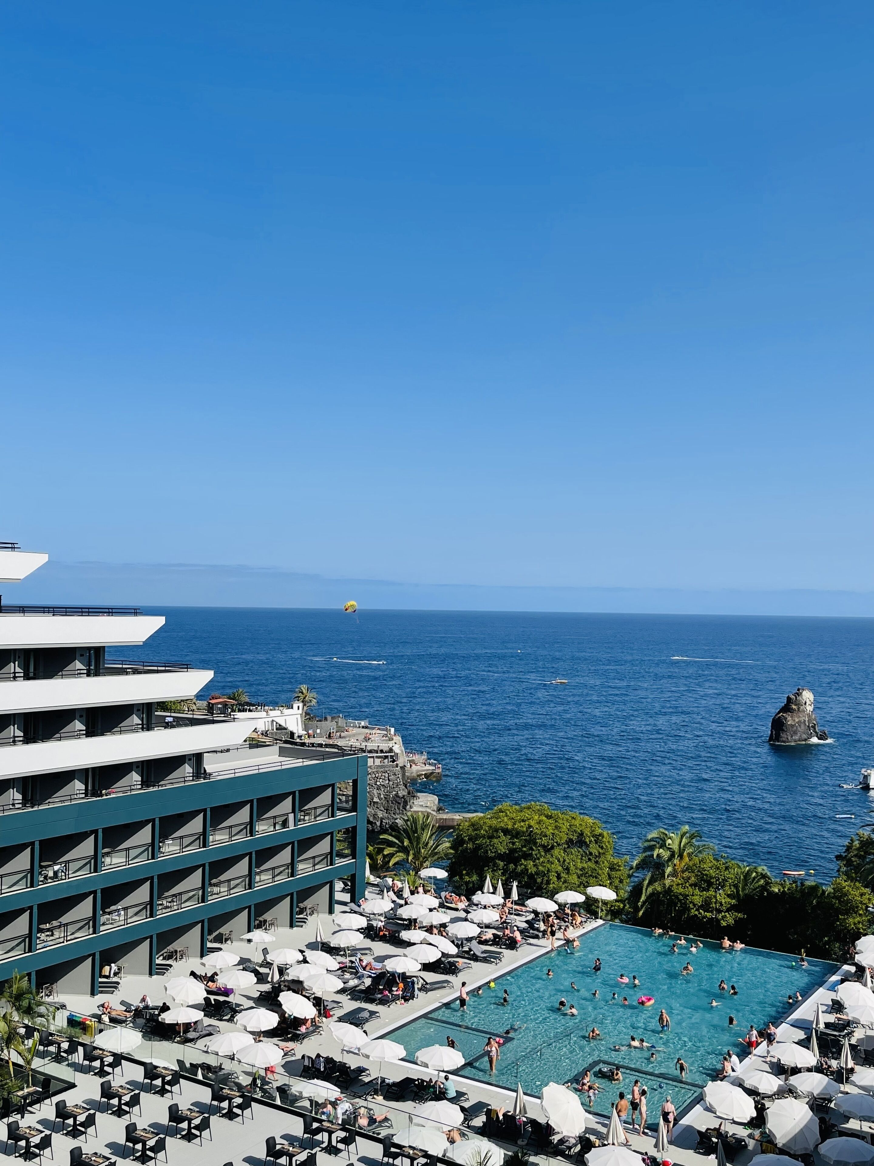 Un complexe hôtelier doté d’une grande piscine, d’un espace extérieur aménagé et offrant une vue sur la mer.