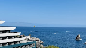 Un complexe hôtelier doté d’une grande piscine, d’un espace extérieur aménagé et offrant une vue sur la mer.