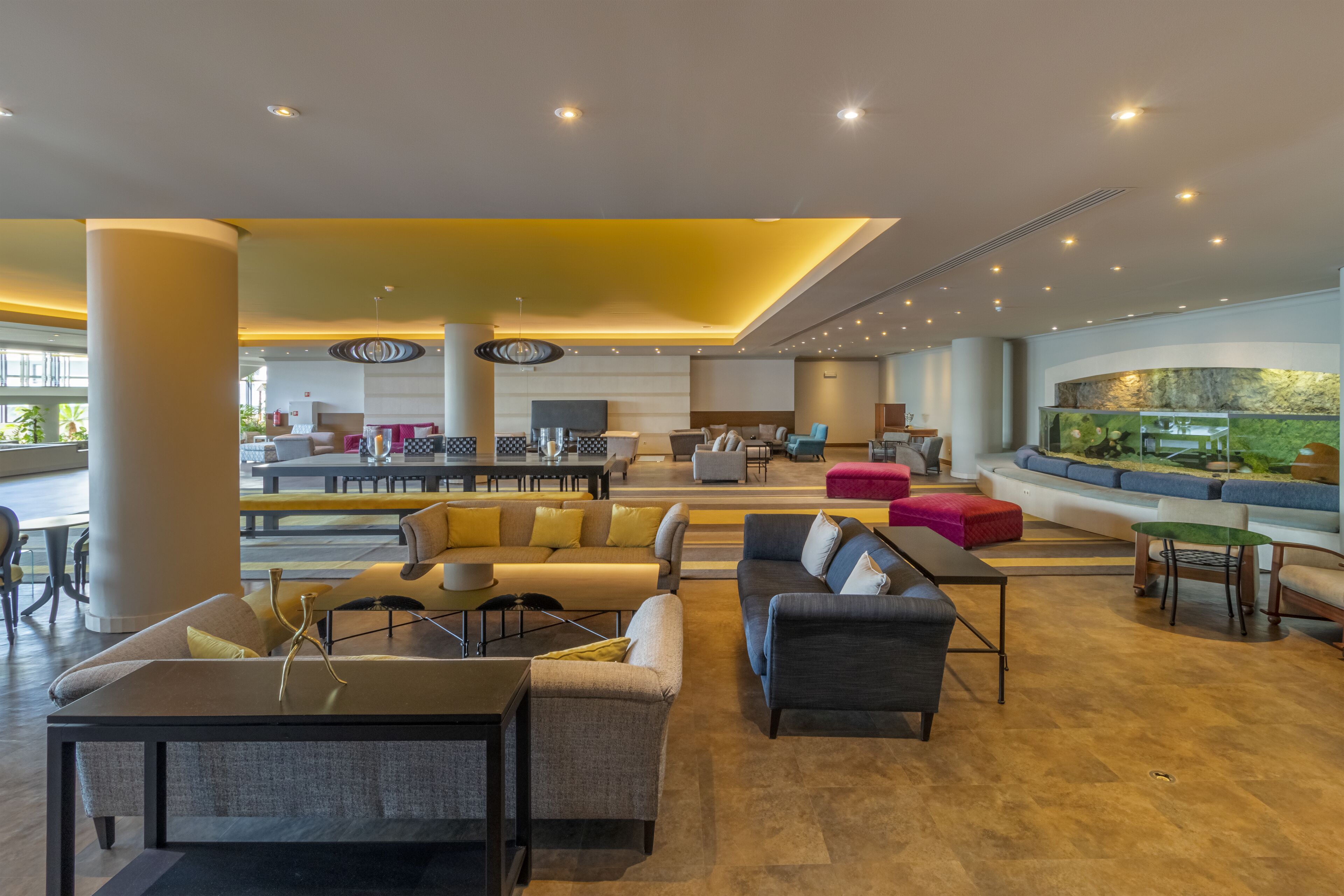 A spacious lobby with a central seating area, a reception desk, and a large aquarium.