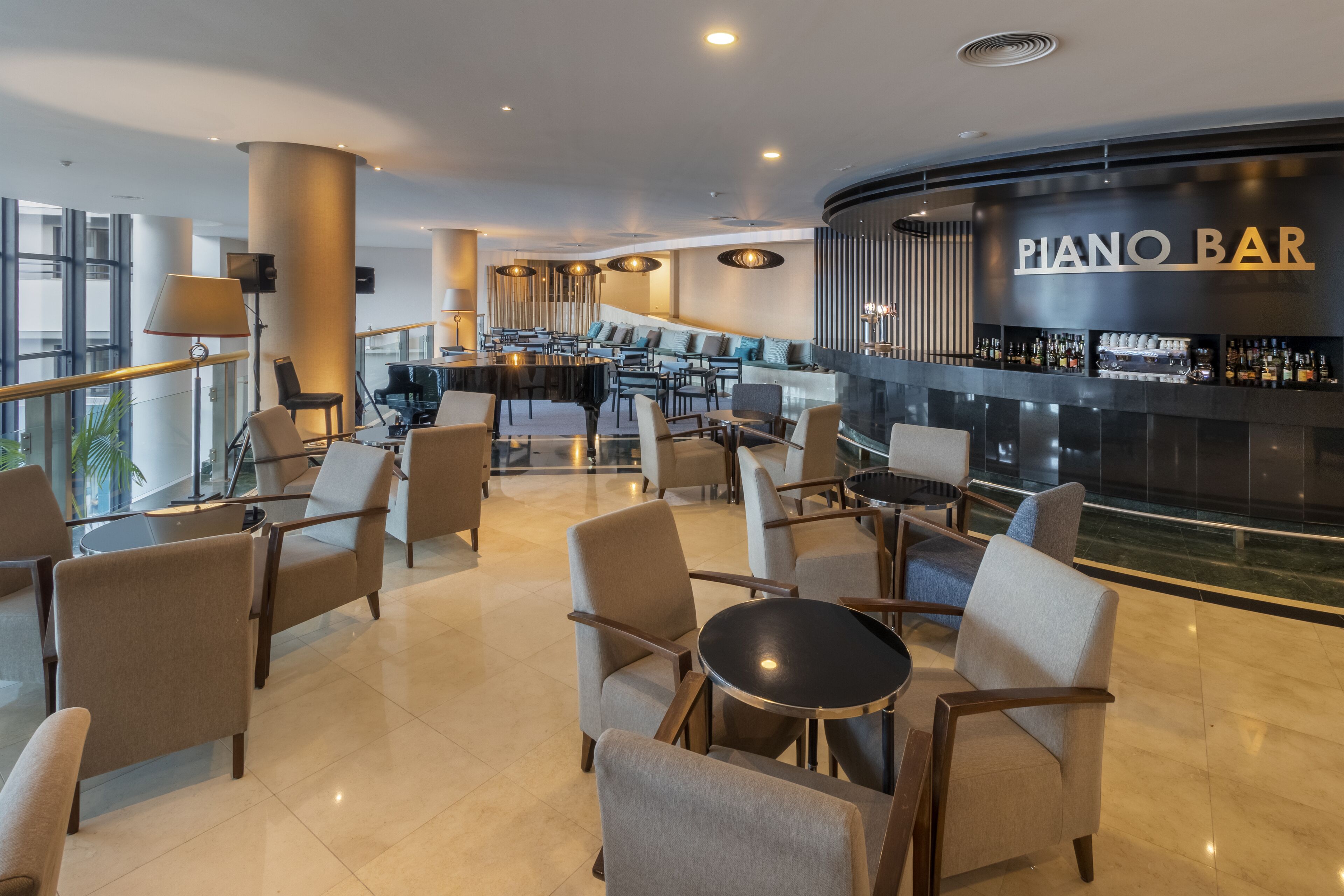 Un área de descanso moderna con un bar de piano, asientos cómodos y una barra.