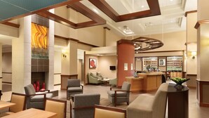 A hotel lobby with seating areas, a fireplace, and a bar. - Hyatt Place Raleigh-Durham Airport (Morrisville)