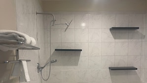 Un baño moderno con una bañera grande, toalleros y estantes empotrados.