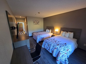 A hotel room with two beds, a desk, and a mirror. - Red Roof Inn & Suites Hinesville (Hinesville)