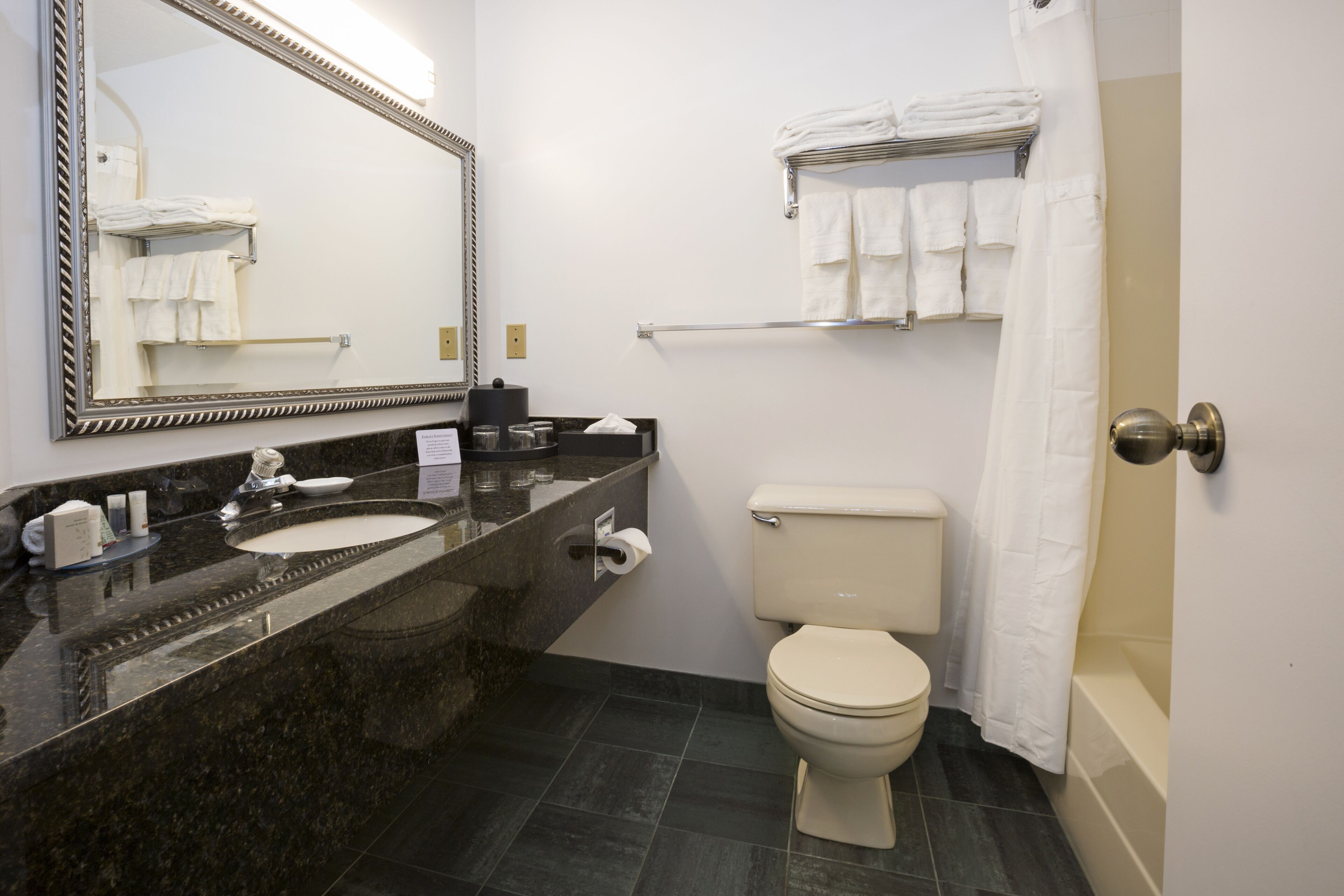 A bathroom with a marble sink, toilet, and bathtub.
