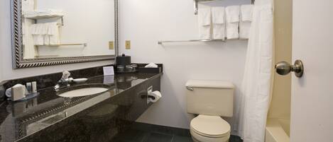 A bathroom with a marble sink, toilet, and bathtub.