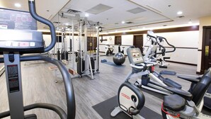A gym with cardio machines, weight training equipment, and a mirrored wall. - Tower Inn and Suites (Quesnel)