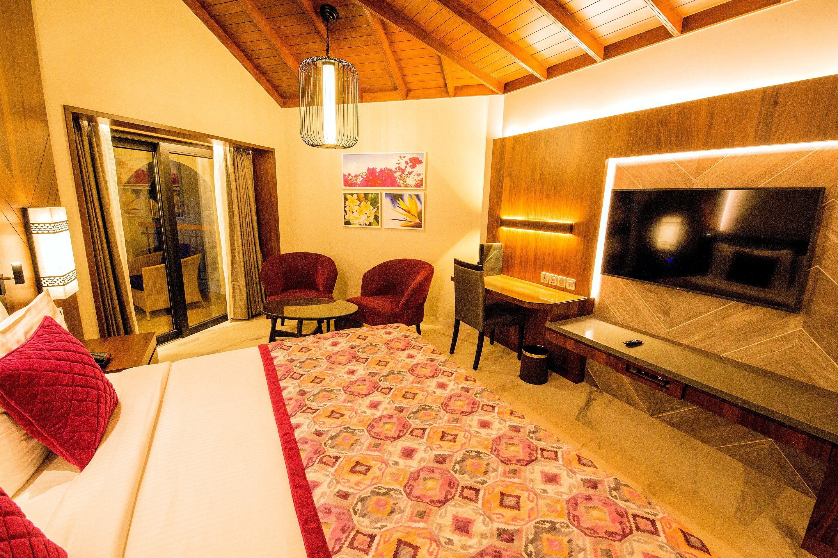 Una habitación de hotel con cama, televisión, escritorio y silla.