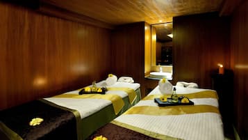 Experience a serene spa retreat with two massage tables, a mirror, and soothing ambiance.