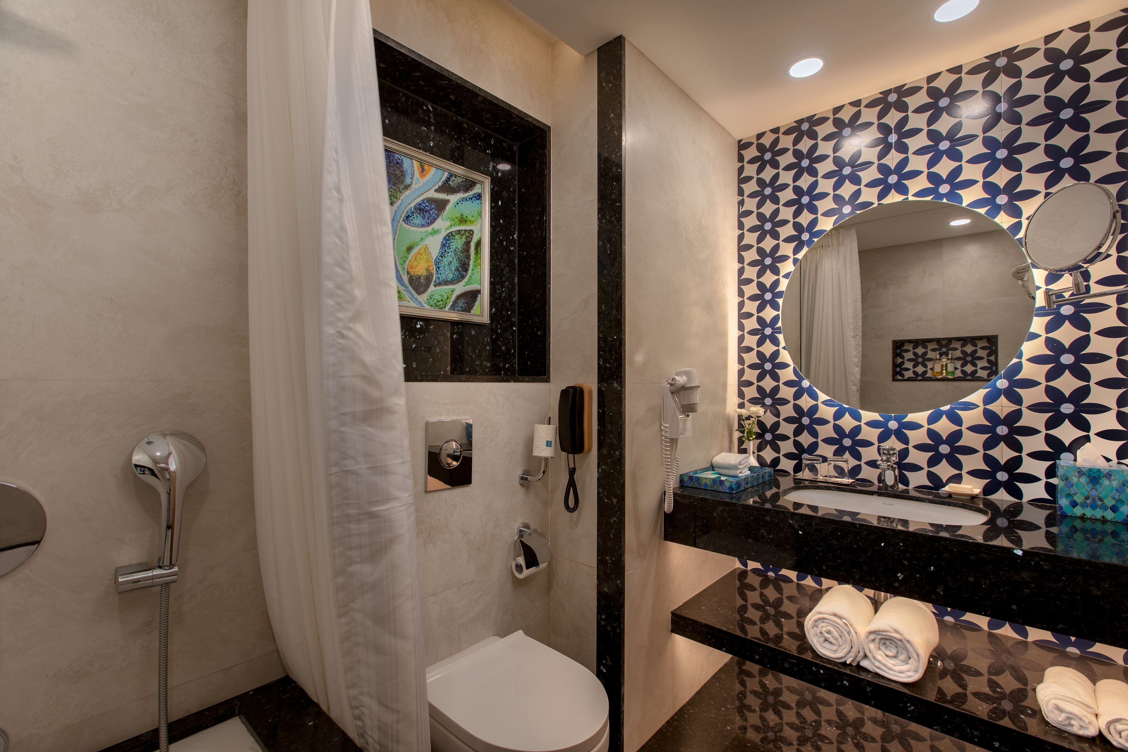 Un bany amb dutxa, vàter i un lavabo amb mirall.