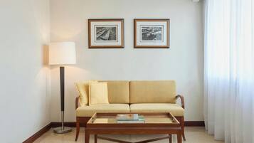 Un salon avec un canapé, une table basse et deux tableaux encadrés accrochés au mur.