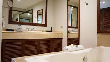 A bathroom with a large mirror, two sinks, a bathtub, and wooden paneling.