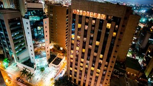 Un edificio de gran altura con varios pisos, amplias ventanas y un patio central.