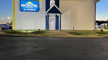 A Microtel Inn & Suites building with a blue and white exterior, a central entrance, and a parking lot in the foreground.