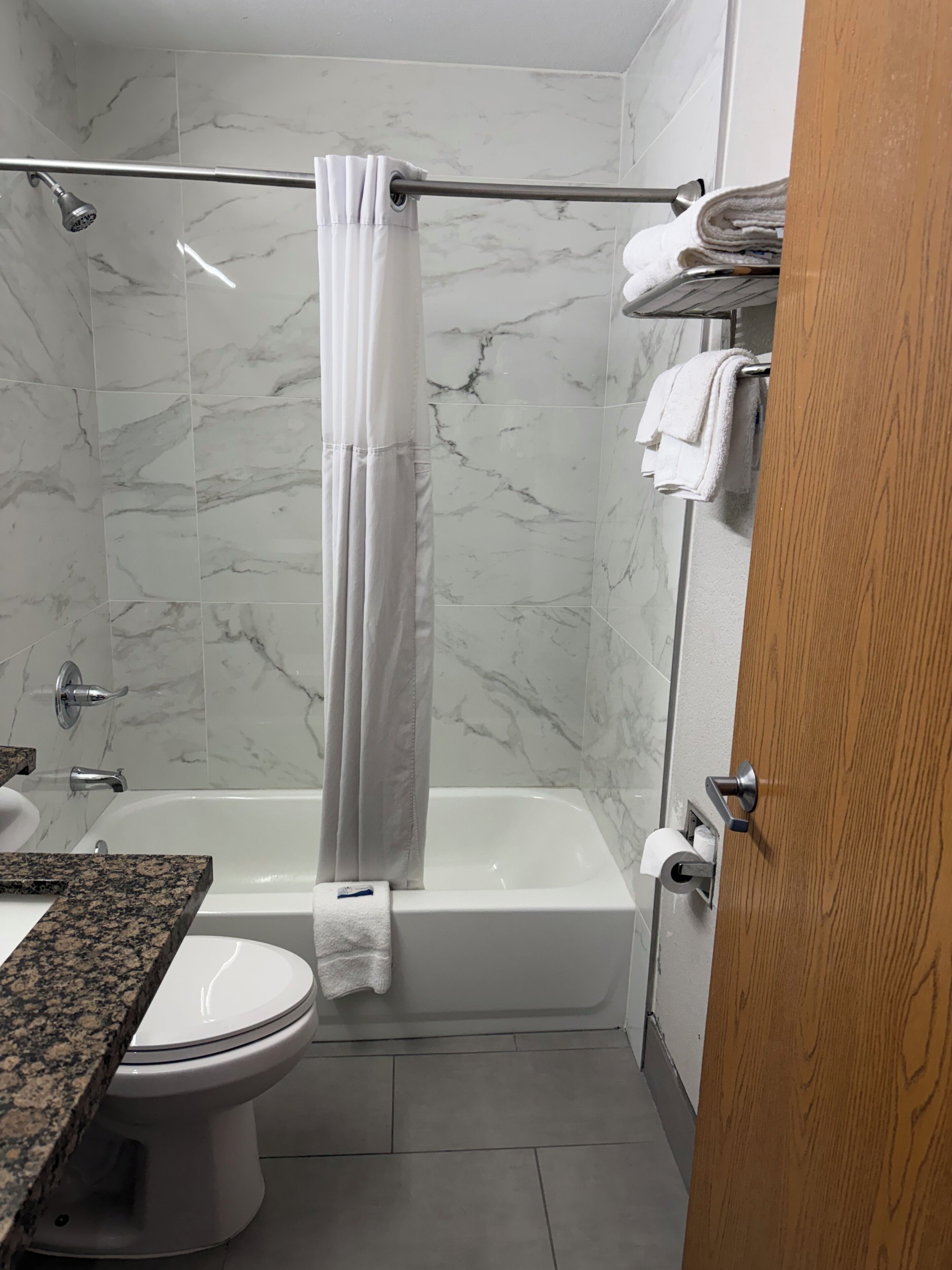 Une salle de bain avec douche, toilettes et lavabo.