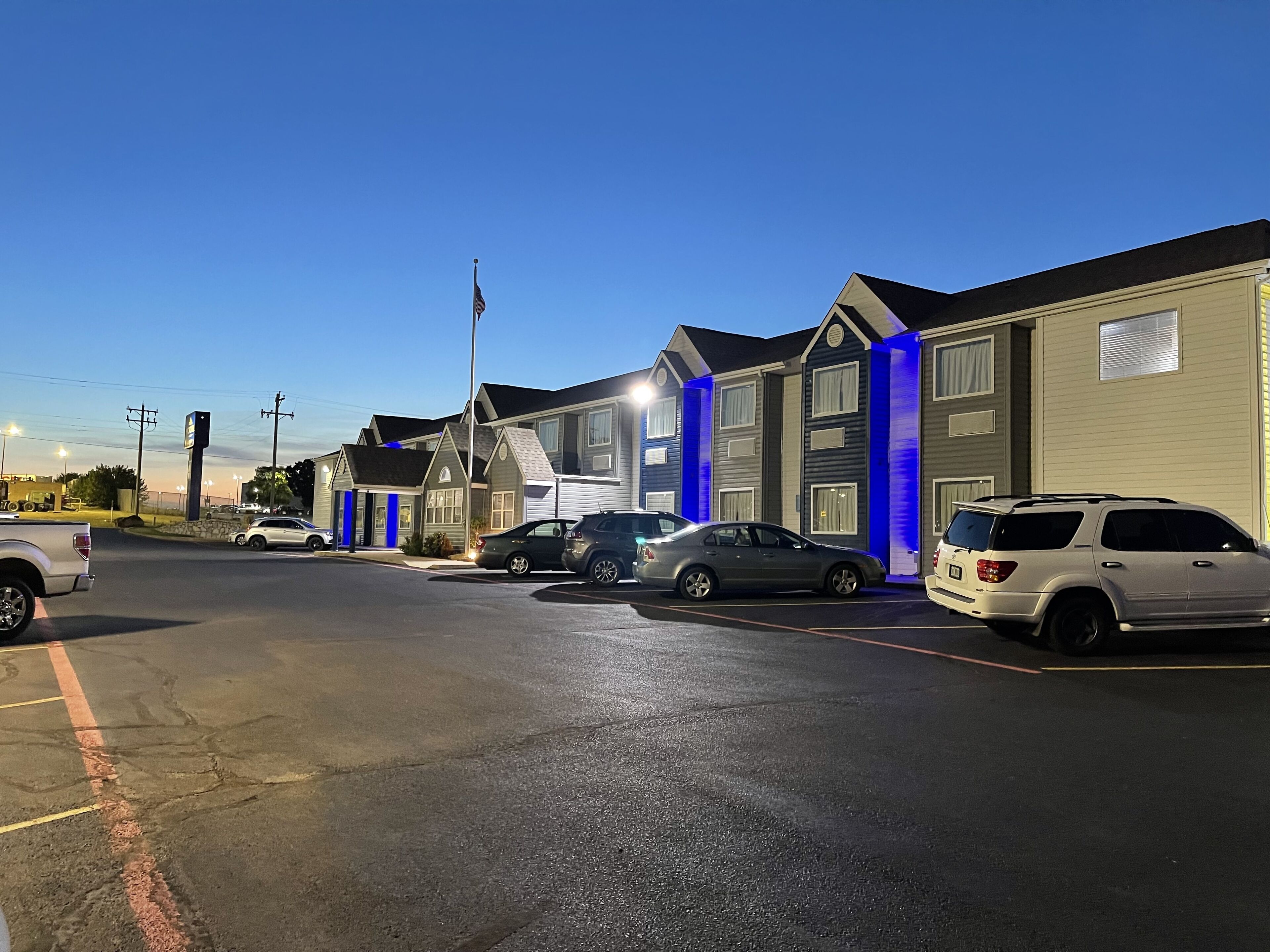 En række motelbygninger med parkeringspladser foran.