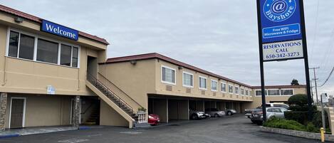 A hotel with a 'Welcome' sign, free WiFi, and a reservation phone number.