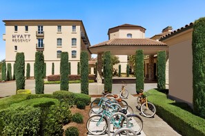 A Hyatt Regency hotel with a well-maintained garden, bicycles, and a clear blue sky. - Hyatt Regency Sonoma Wine Country (Santa Rosa)