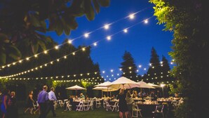 An outdoor event with string lights, tables, chairs, and umbrellas. - Hyatt Regency Sonoma Wine Country (Santa Rosa)