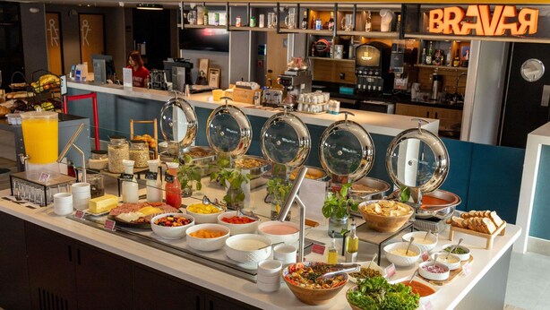 Mostrador de buffet con diferentes alimentos y una estación de café.
