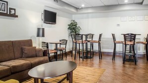 A furnished living area with a sofa, coffee table, and dining chairs.