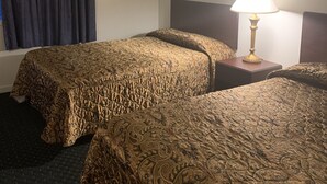 A hotel room with two beds, a window with curtains, a lamp, and a framed picture on the wall.