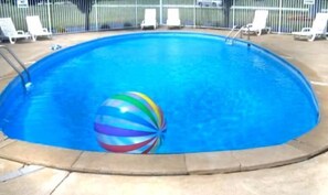A swimming pool with a colorful beach ball and lounge chairs around the perimeter. - Monticello Inn (Monticello)